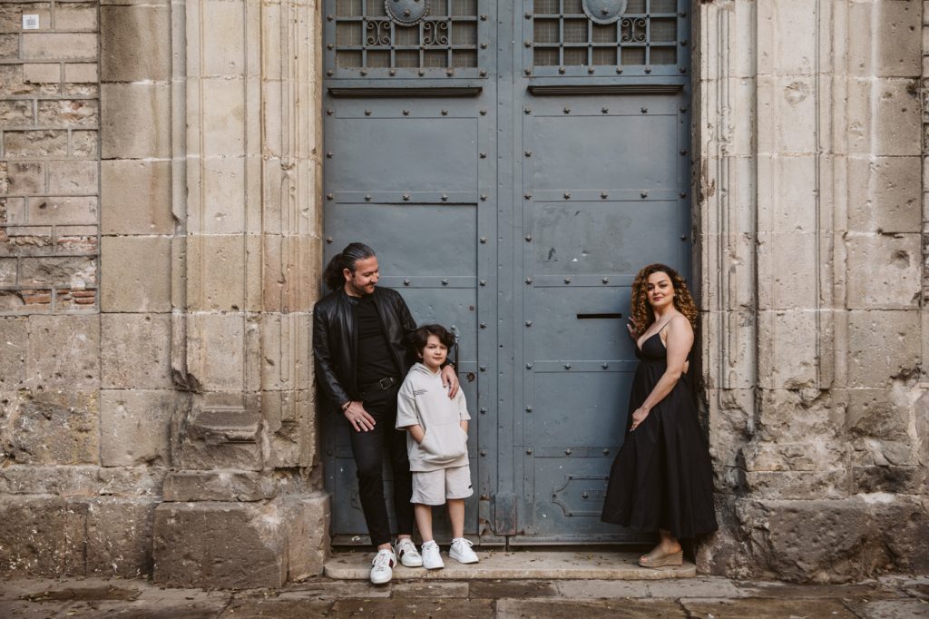 Family posing for a photo in the Gothic Quarter in Barcelona, wearing black. The small boy is wearing light grey sports suit.